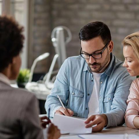 Notary helping clients sign docs